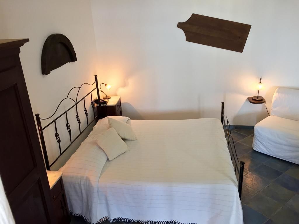 A bedroom with a bed, bedside tables, and wall-mounted lamps.