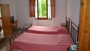 A bedroom with a single bed, a wooden wardrobe, a desk with a chair, and a window with curtains. - Albergo Padellino (Vaglia)