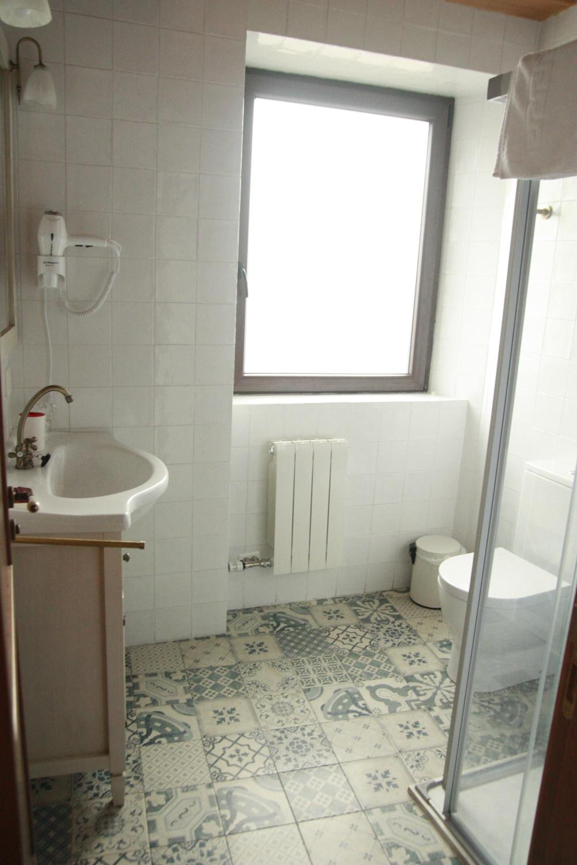 Un baño con lavamanos, inodoro y ducha.