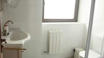 Un baño con lavamanos, inodoro y ducha.