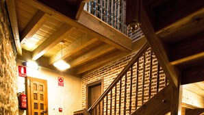 Una escalera de madera con barandilla de metal que conduce a un segundo piso.