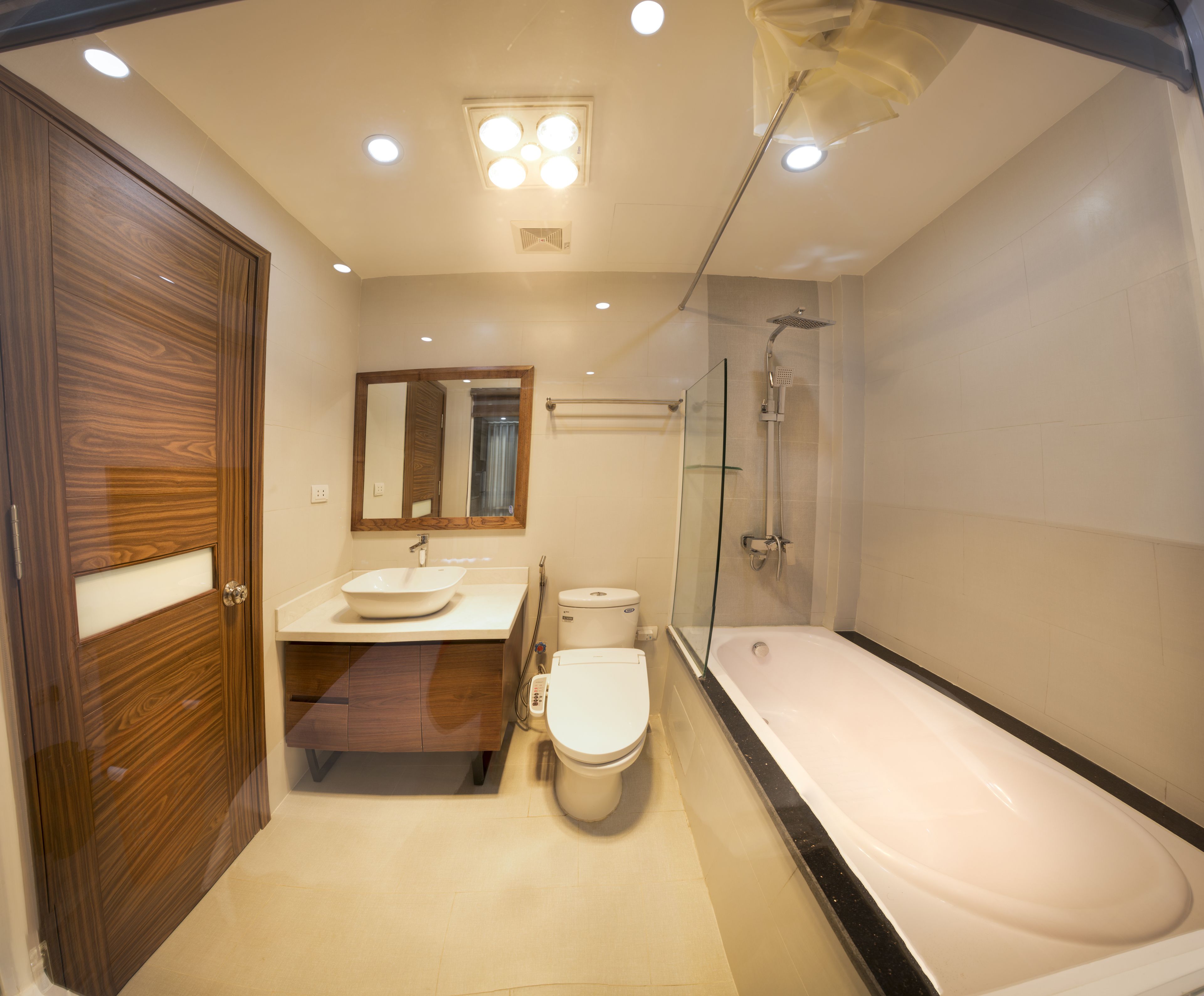 A modern bathroom with a wooden door, a sink, a toilet, and a bathtub.