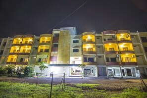 Vista frontal de la propiedad por la tarde o noche