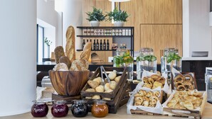 A buffet with various breads, pastries, and condiments. - Residence Inn by Marriott Frankfurt City Center (Frankfurt)