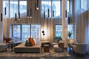 A modern living room with a sofa, armchairs, a coffee table, and a plant. - Residence Inn by Marriott Frankfurt City Center (Frankfurt)
