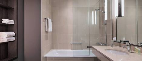 A modern bathroom with a glass-enclosed shower, a bathtub, and a vanity with a sink.