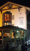 A two-story hotel with a prominent sign reading "HOTEL del Ville."