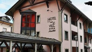 Un edificio rosa con un cartel que dice "HOTEL de Ville Marble".