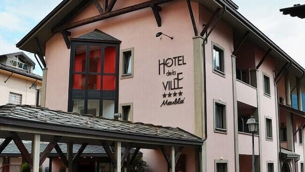 A pink building with a sign that reads "HOTEL de Ville Marble".