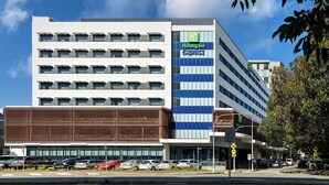 A Holiday Inn Express hotel with a modern facade, multiple floors, and a parking lot in front.