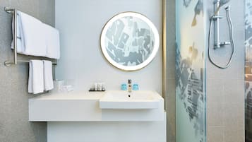Une salle de bain moderne avec un lavabo, un miroir et une douche.