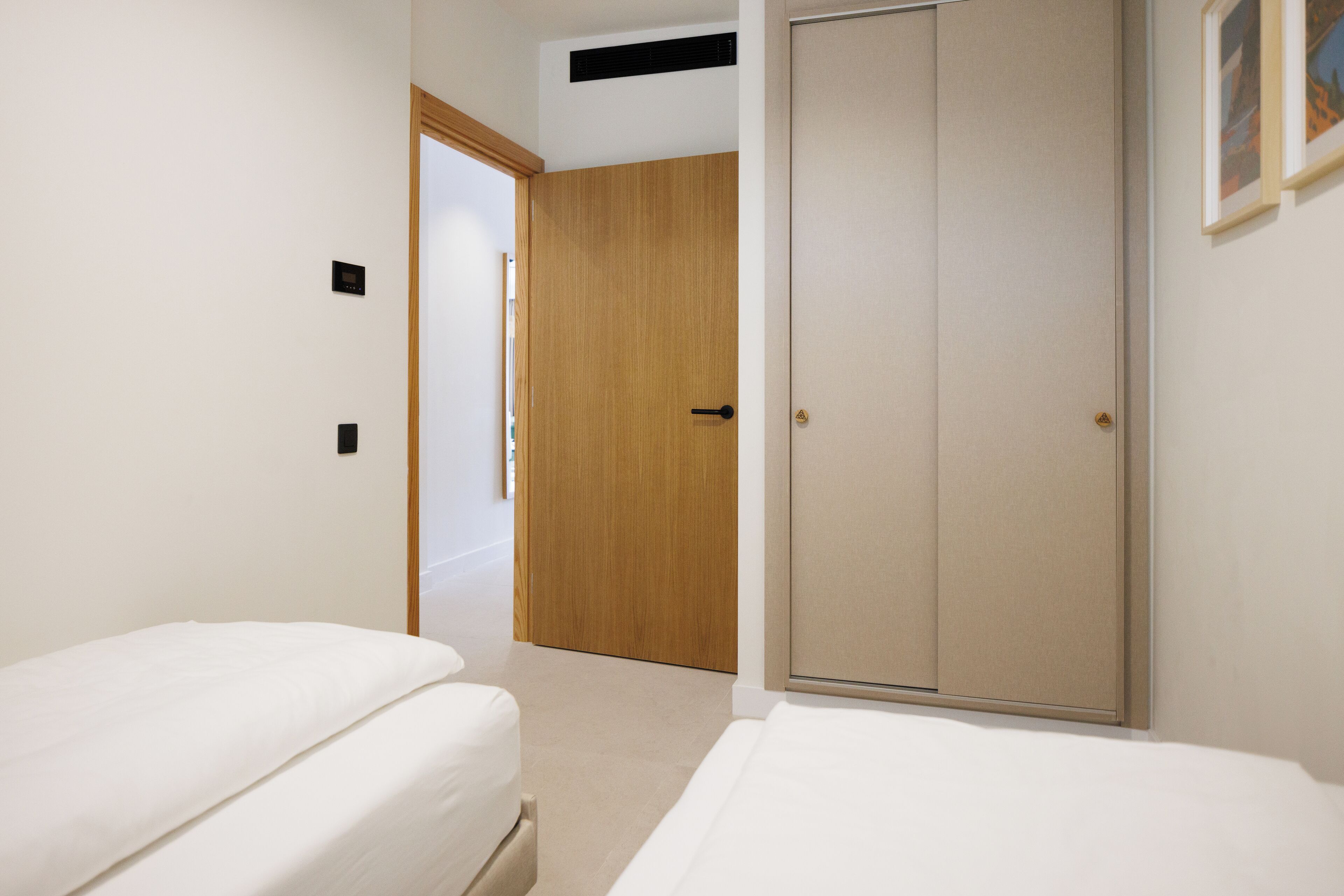 Une chambre d’hôtel avec un lit, une armoire et une porte donnant sur une autre pièce.