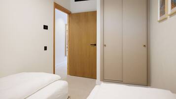 Une chambre d’hôtel avec un lit, une armoire et une porte donnant sur une autre pièce.