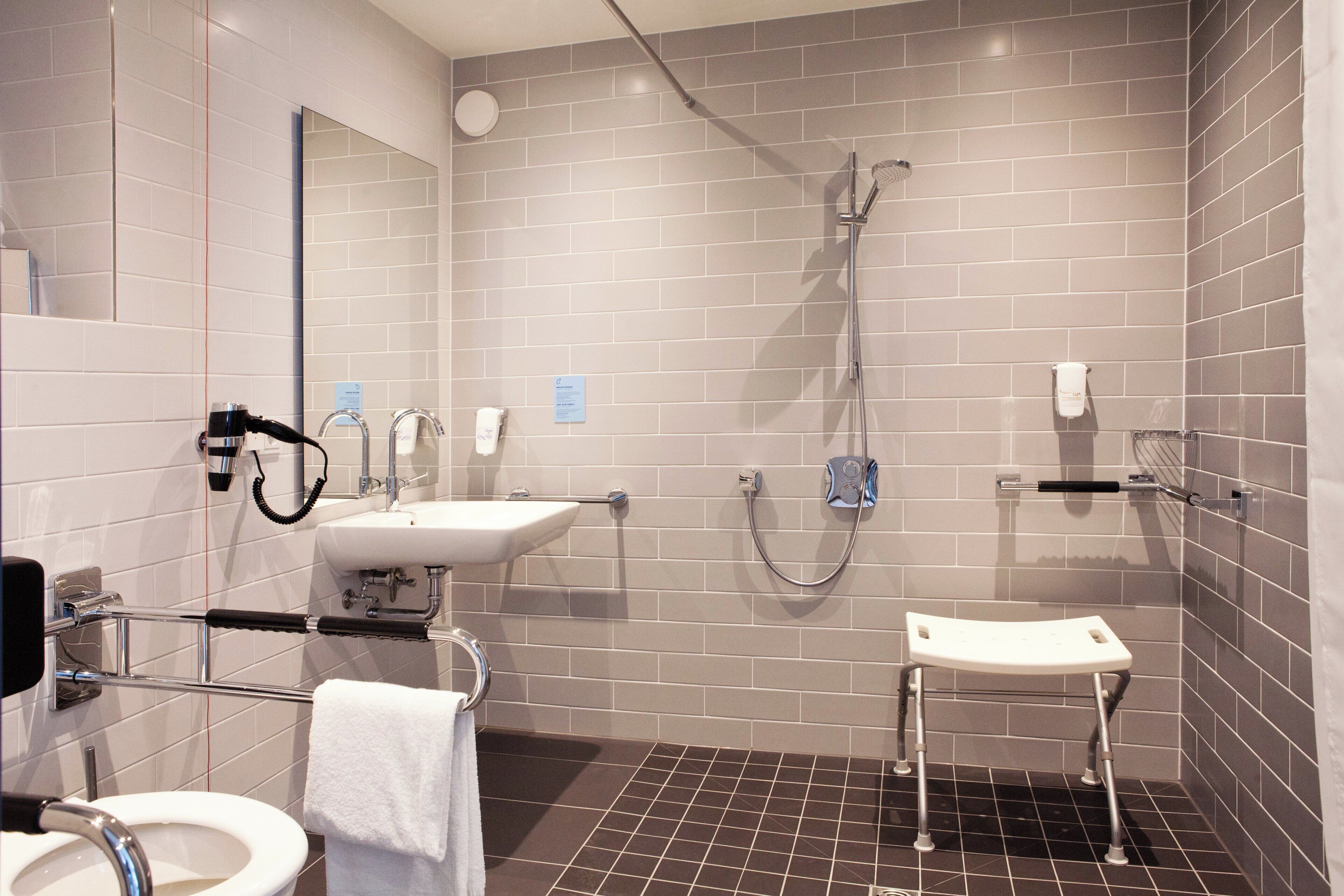 A modern bathroom with a shower, toilet, and sink.