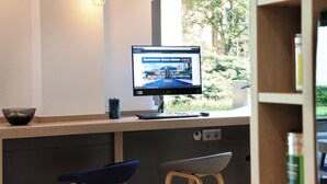 Una cocina moderna con estufa integrada, un fregadero y ventana con vistas a un jardín.