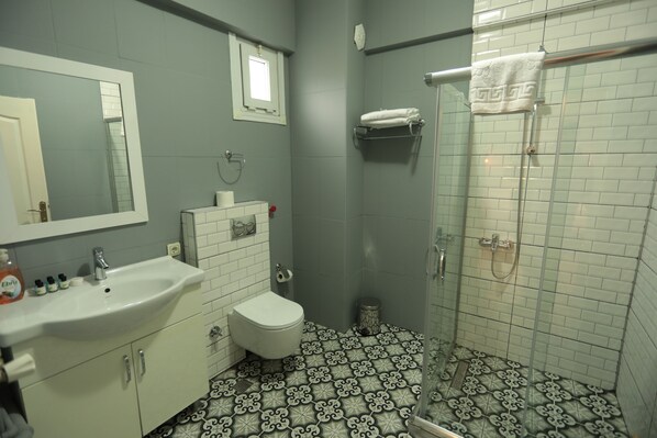 A bathroom with a sink, toilet, and shower. - White Pearl Apart (Istanbul)
