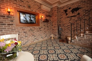 Cozy retreat with a rustic brick wall, patterned tile floor, and a wooden-framed picture.