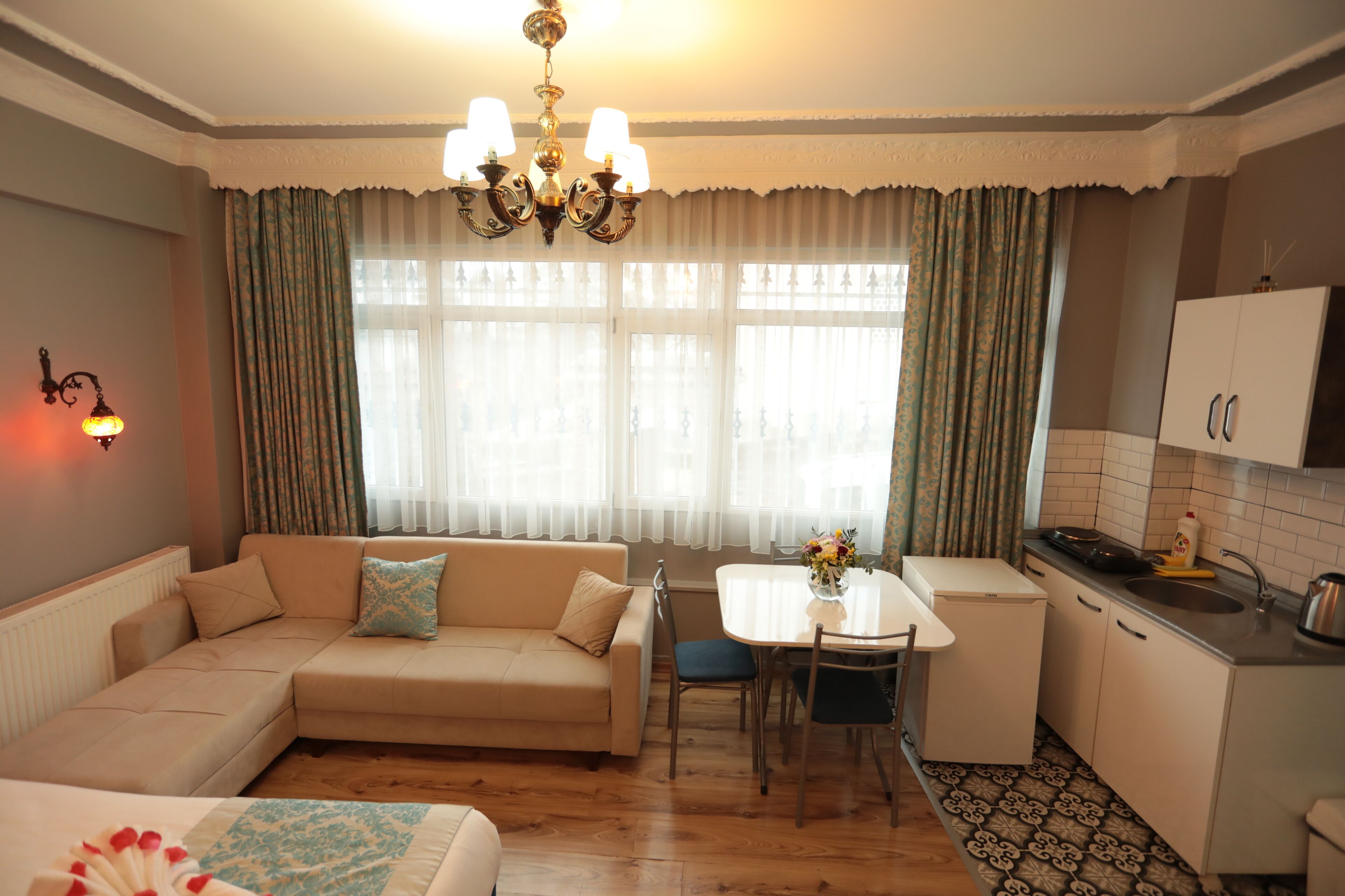 A cozy living area with a sofa, a dining table, and a kitchen.