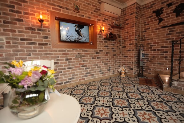 Cozy room with a brick wall, patterned floor, and decorative touches.