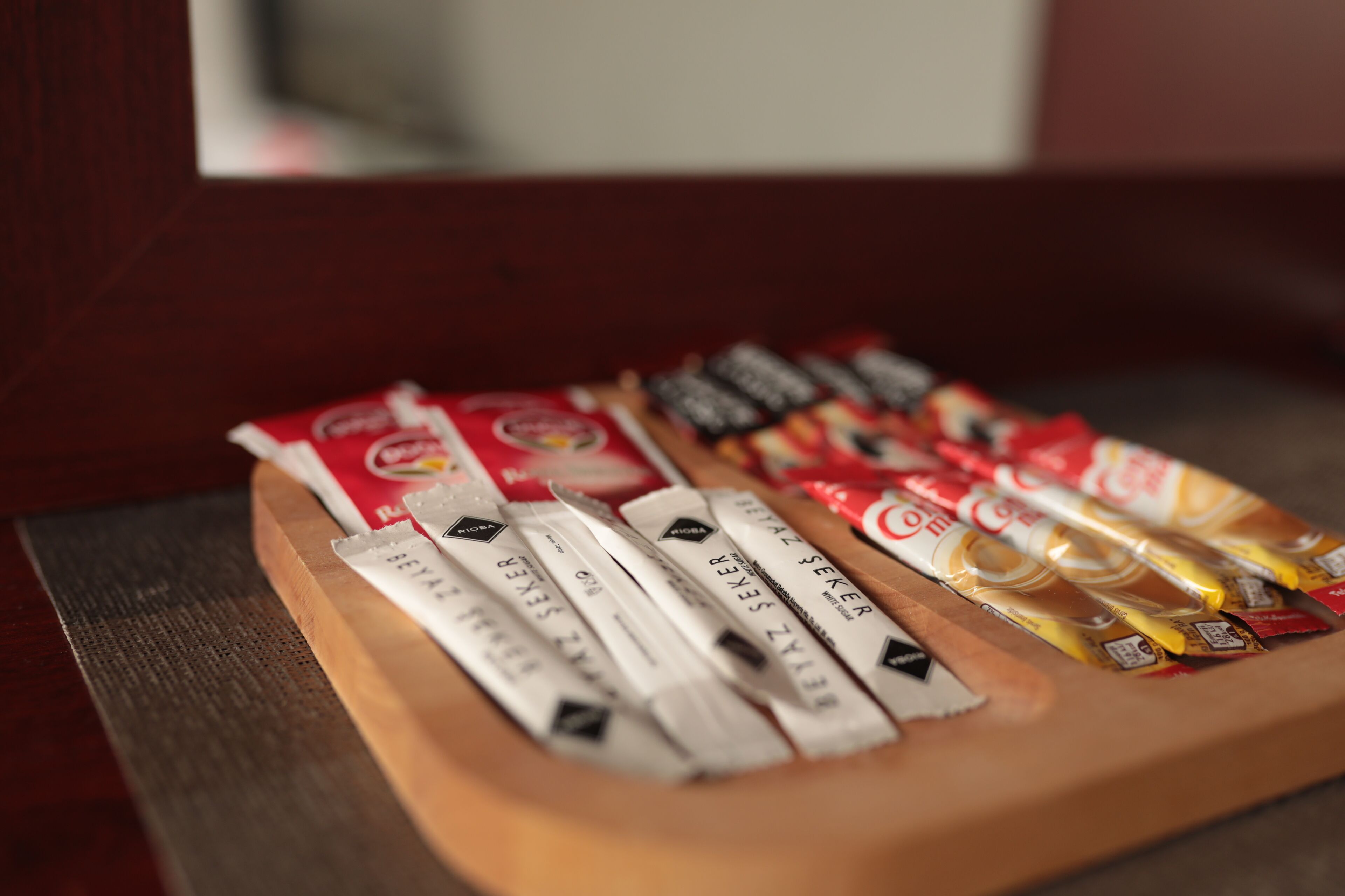 A wooden tray with various coffee packets.