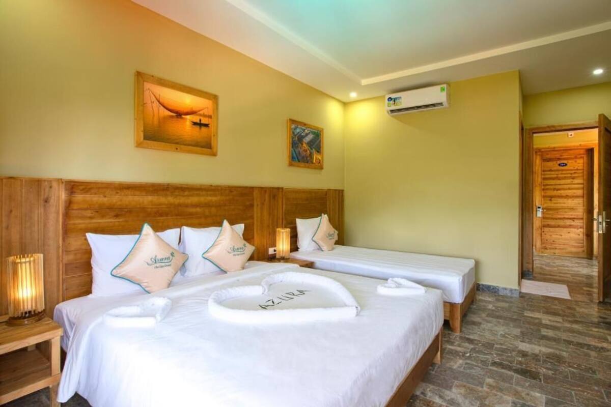 A hotel room with two beds, wooden headboards, and a painting on the wall.