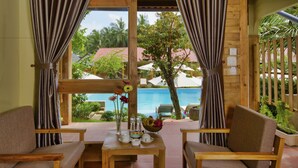 A wooden-framed room with a view of a pool and tropical scenery. - Azura Resort Phu Quoc (Phu Quoc)