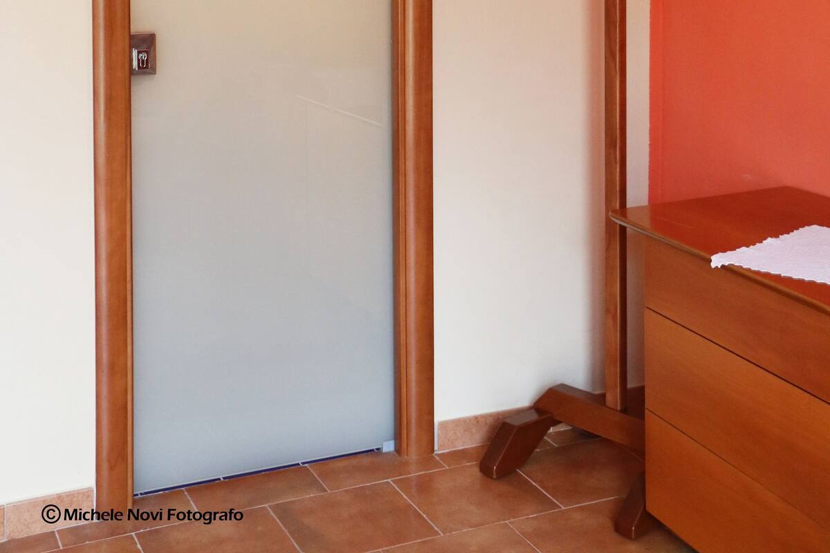 Een hotelkamer met een houten deur, een kapstok en een klein houten dressoir.