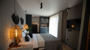 Un dormitorio moderno con cama, lámparas de noche, un sofá y un televisor.