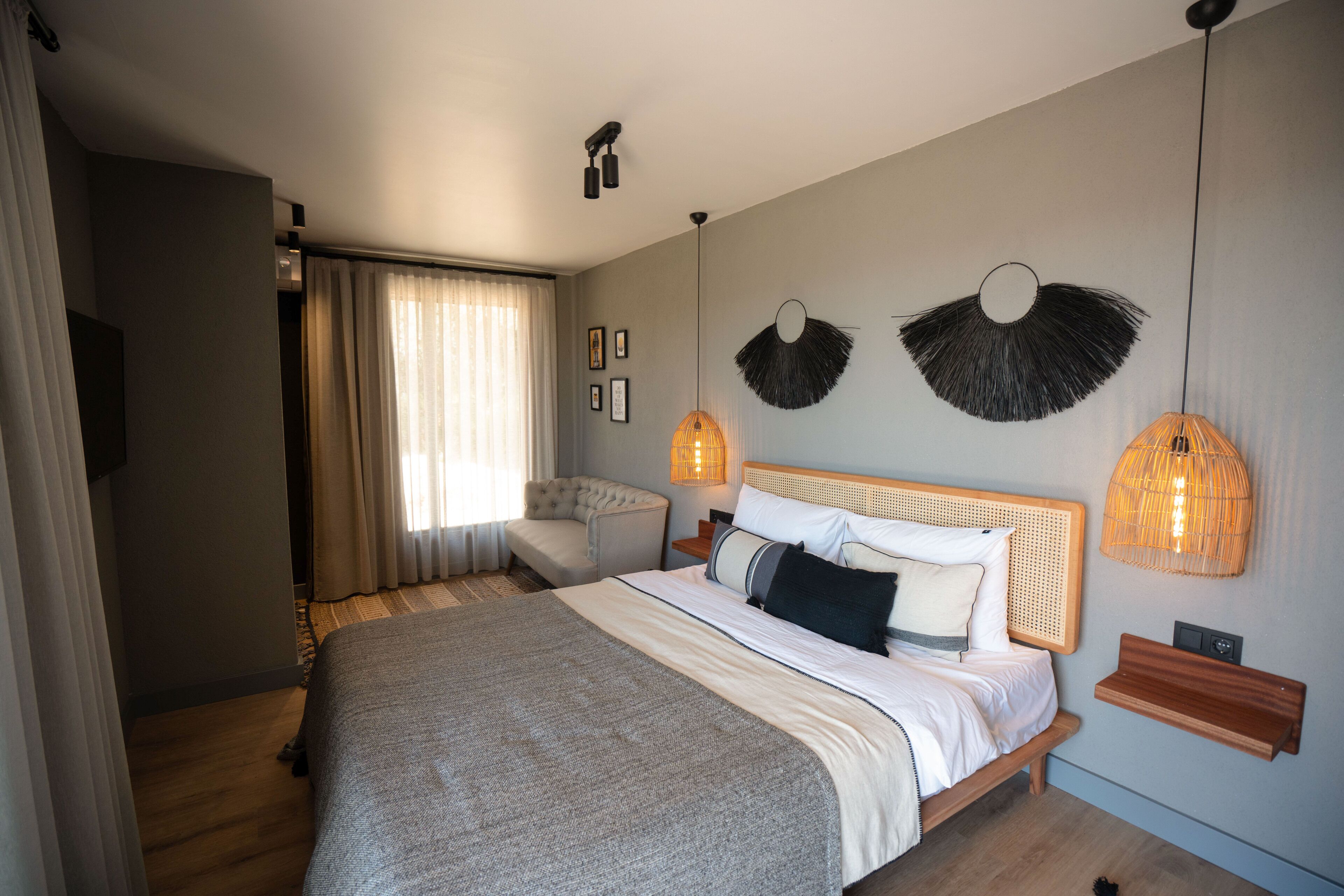 Ein modernes Schlafzimmer mit einem großen Bett, einer Couch und zwei Wandleuchten.
