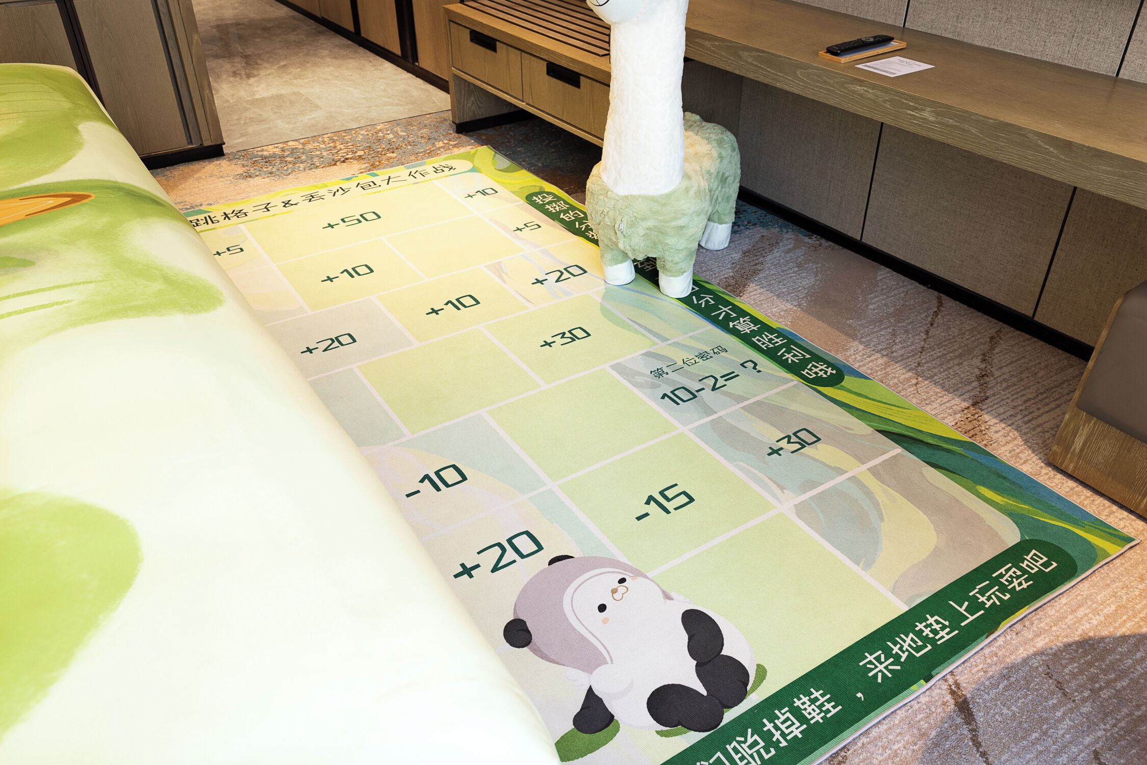 A hotel reception area with a reception desk, a plush toy, and a floor plan with directional arrows.