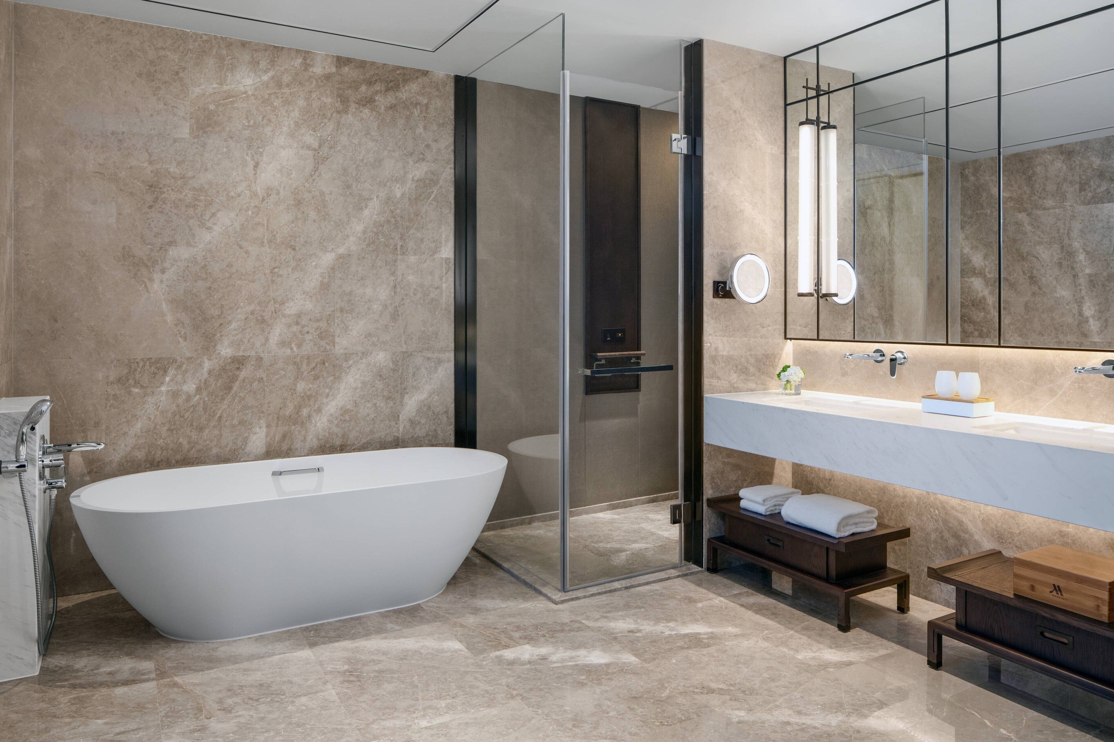 A modern bathroom with a freestanding bathtub, a glass-enclosed shower, and a vanity with a mirror.
