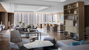 A modern hotel lobby with a dining area, seating, and a large bookshelf. - Hangzhou Marriott Hotel Lin'an (Hangzhou)