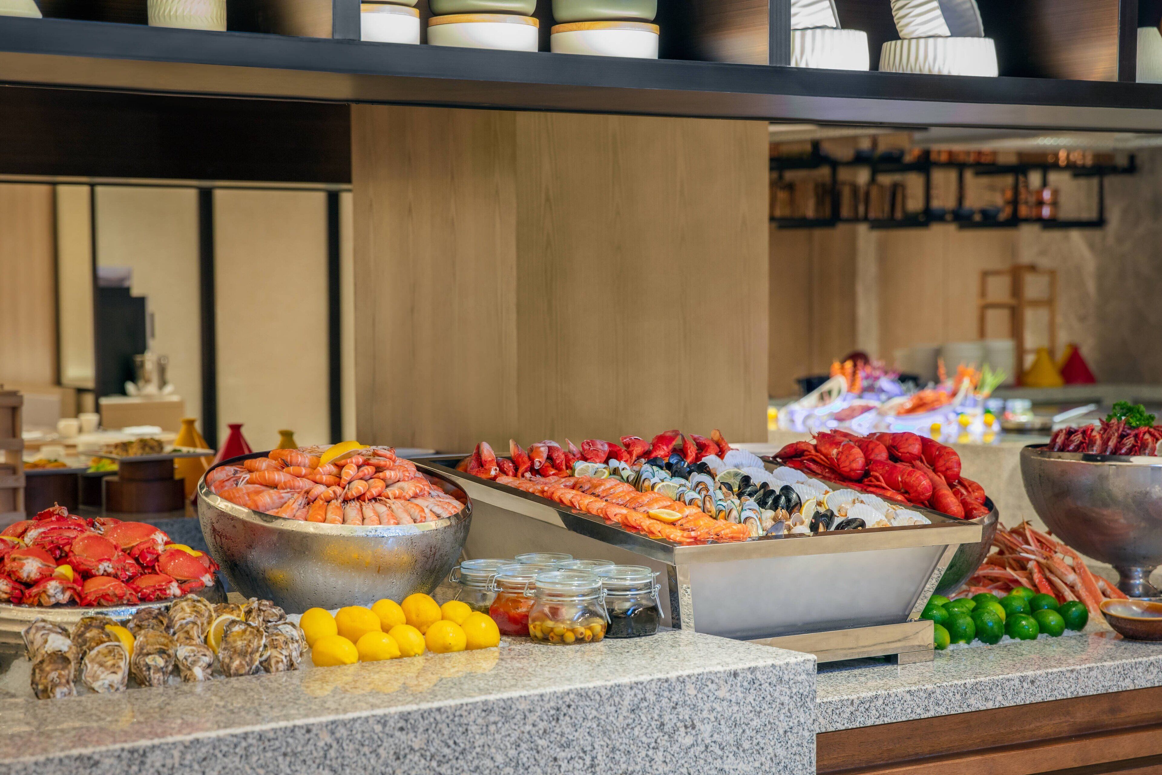 A buffet with various seafood options including shrimp, lobster, and oysters.