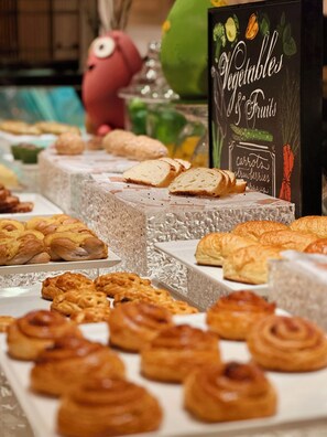 A display of various baked goods including bread, pastries, and cookies.
