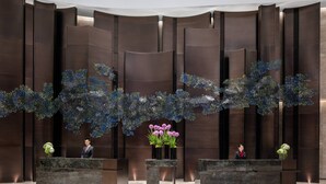 A reception area with two reception desks, a decorative ceiling installation, and a large wall with vertical panels. - Hangzhou Marriott Hotel Lin'an (Hangzhou)