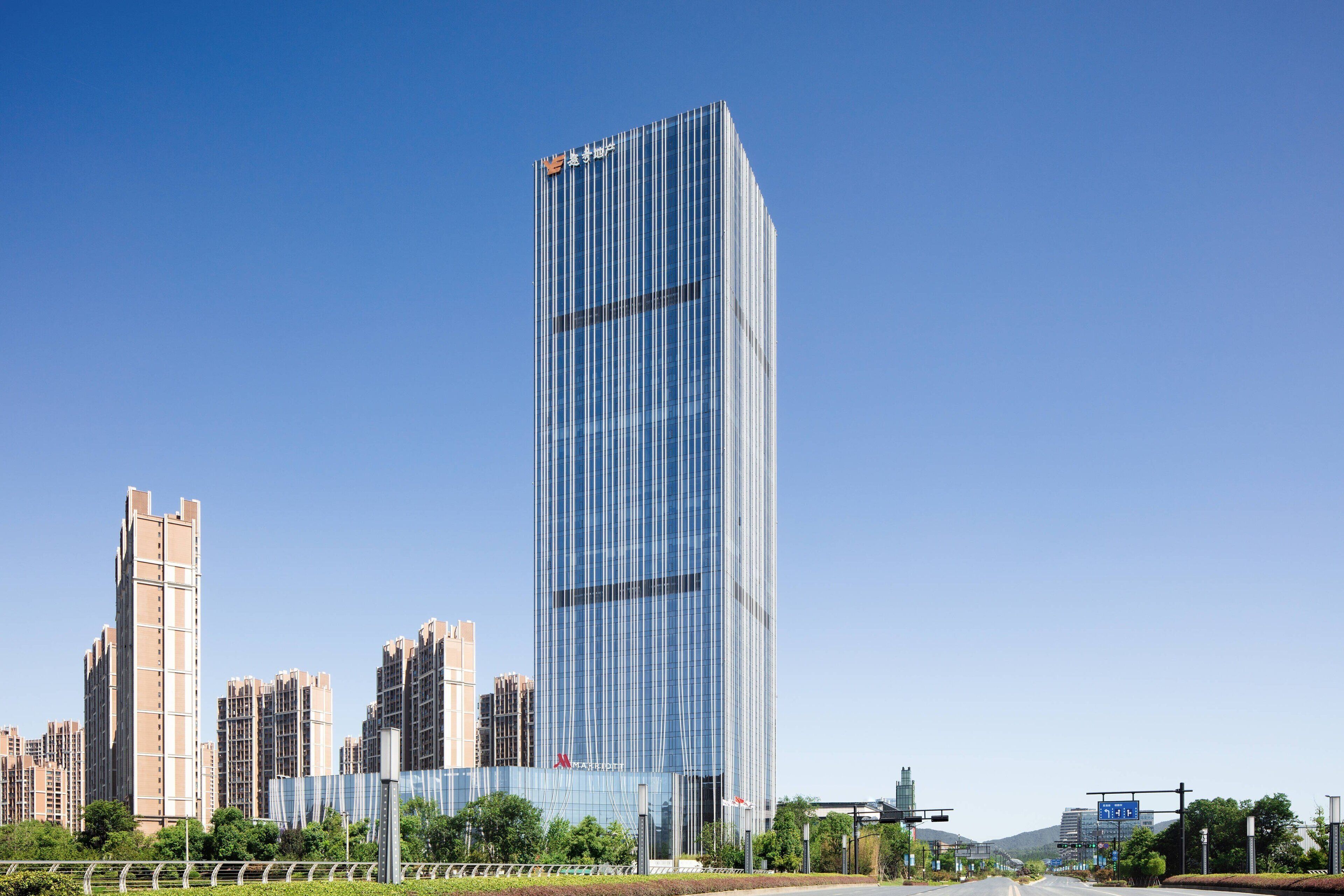 Un immeuble moderne de grande hauteur, doté d’une façade en verre, entouré d’autres immeubles de grande hauteur.