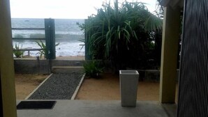 A view of the ocean from a doorway with a concrete planter and a metal gate. - Asiri Yoga Retreat (Boossa)