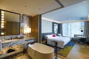 A modern hotel room with a marble bathroom, a large bed, a sitting area, and a view of the city. - Renaissance Hangzhou Northeast Hotel (Hangzhou)