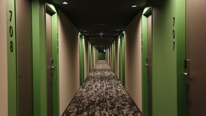 A hotel hallway with green doors numbered 708 and 707, carpeted floor, and a ceiling with recessed lighting. - ibis Styles Tokyo Bay (Urayasu)