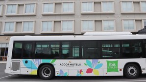 A bus with 'AccorHotels' and 'ibis Styles' branding, parked in front of a building with multiple windows. - ibis Styles Tokyo Bay (Urayasu)