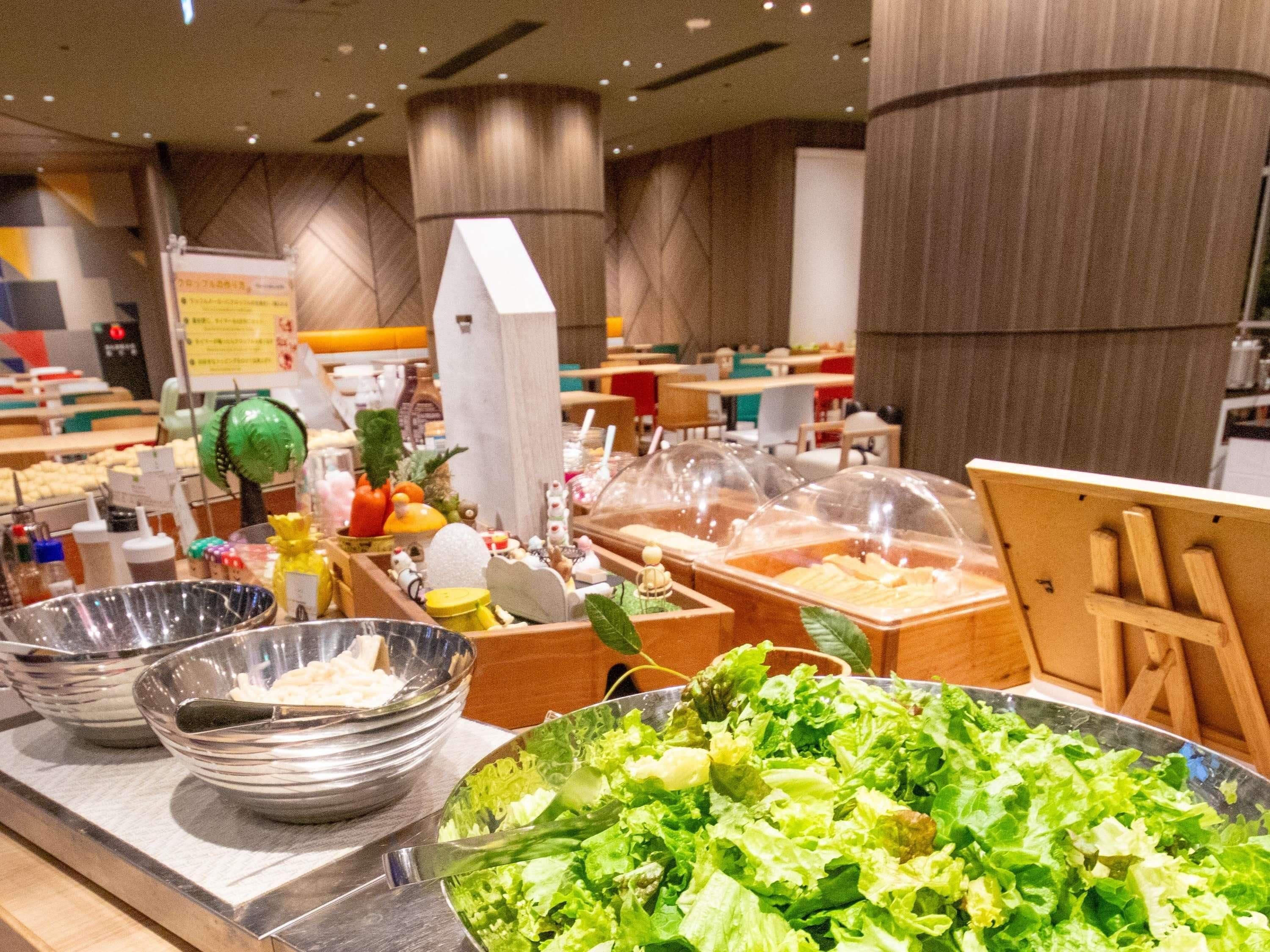 A buffet area with various food items and a large salad bowl.