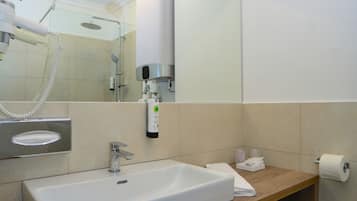 Un baño moderno con un lavamanos grande, un espejo y un perchero para toallas.