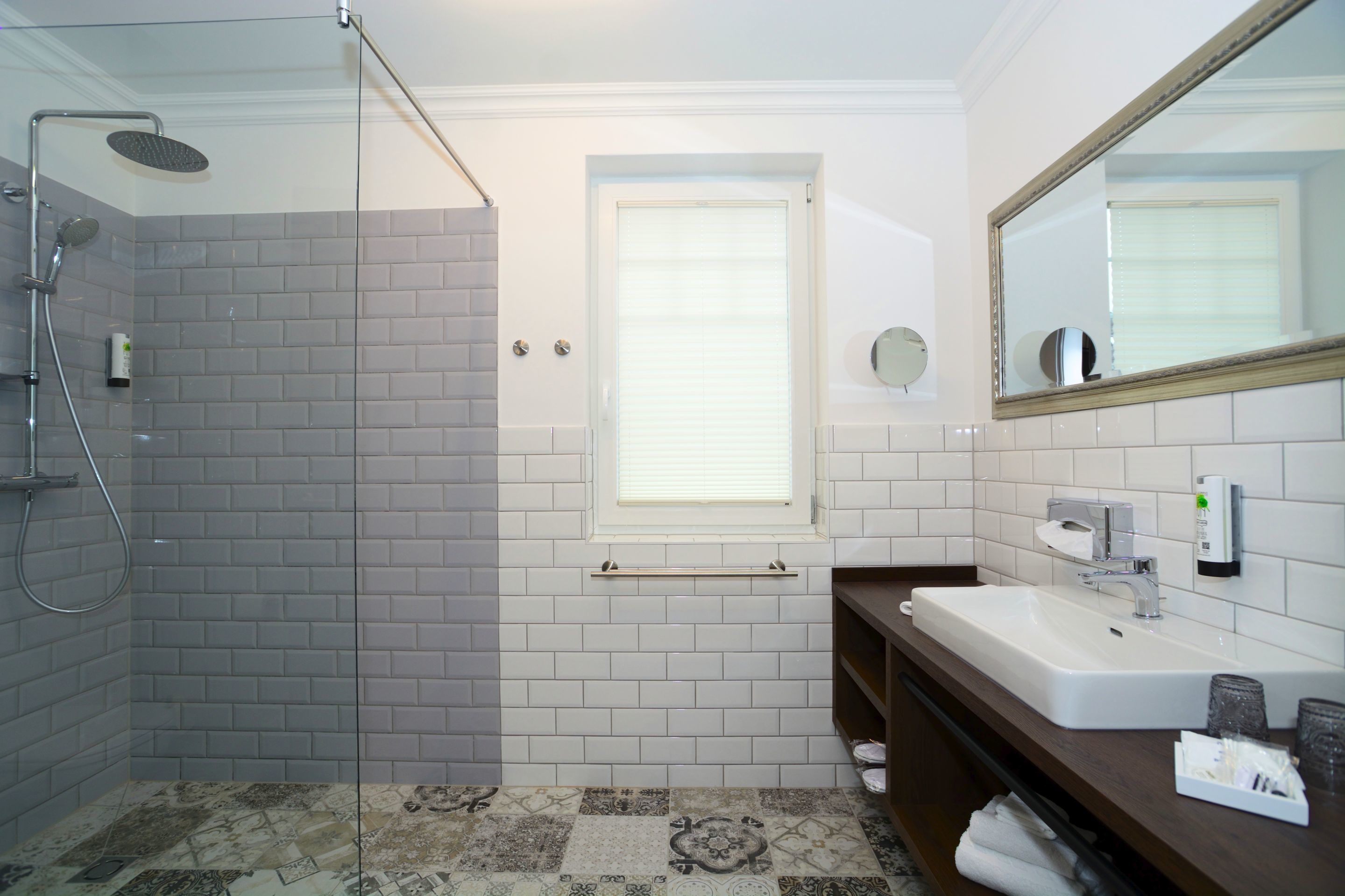 Ein Badezimmer mit Dusche, Waschbecken und Spiegel.