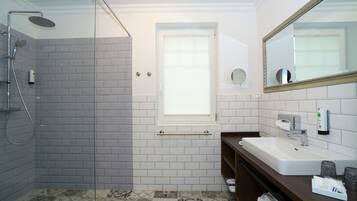 Ein Badezimmer mit Dusche, Waschbecken und Spiegel.