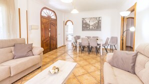 A living room with two sofas, a coffee table, and a dining area with chairs and a table. - Cubo's Villa Gertrudis. Air conditioning, private pool, wifi. (Alhaurín el Grande)