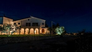 Un edificio moderno de dos pisos con fachada blanca y varios ventanales en arco.