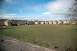 A row of townhouses with a grassy field in front. - Old Bakery Cosy Cottage in Bath - 3 Bedroom, Free (Bath)