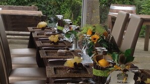 A long table set with wicker trays, silverware, and sunflowers. - Les Chambres d'Hôtes du Mont Monnet (Longes)
