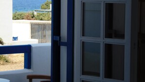 Una habitación con vista al mar y un balcón.