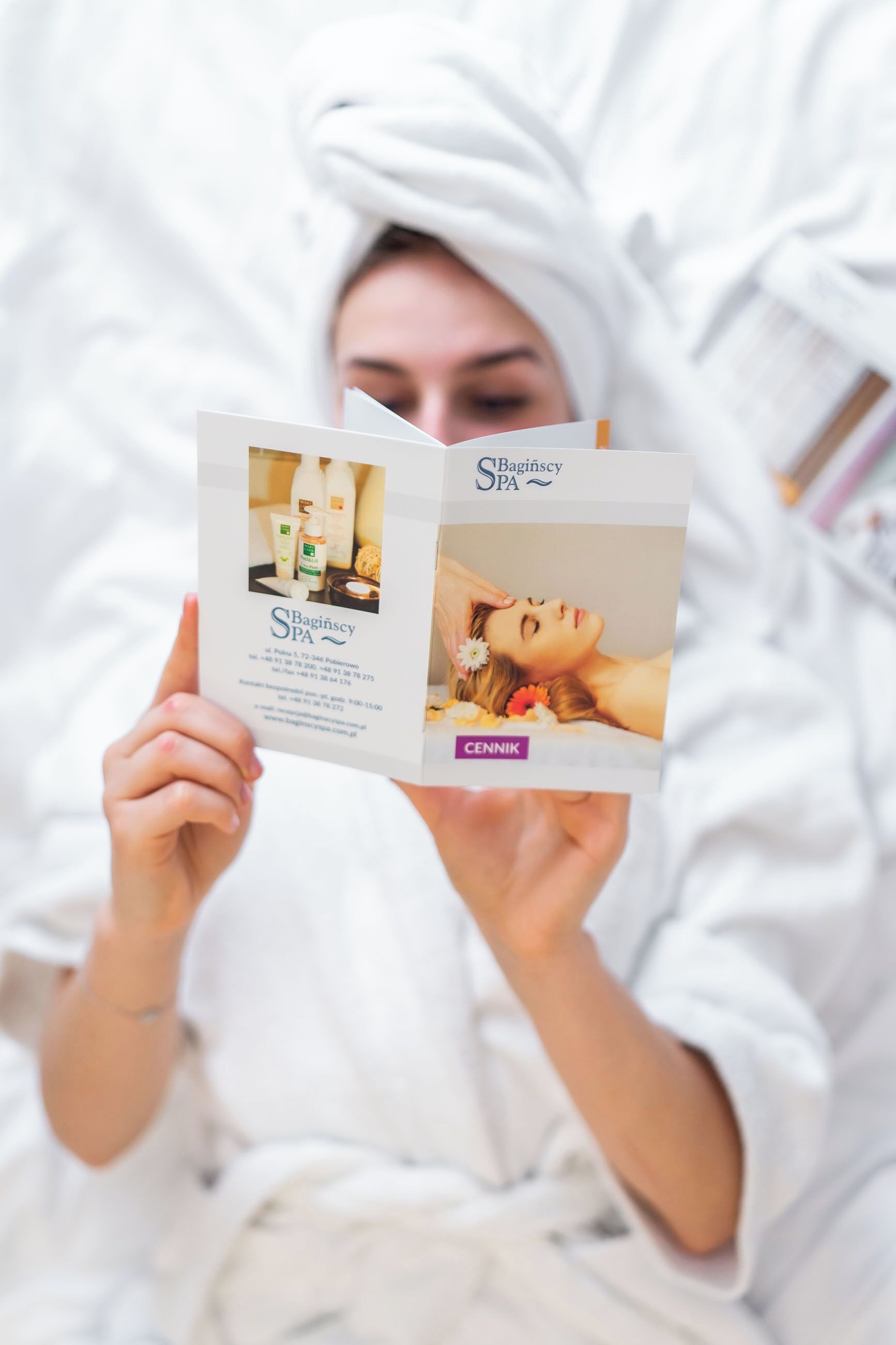 A brochure for a spa with contact details and a photo of a person receiving a treatment.